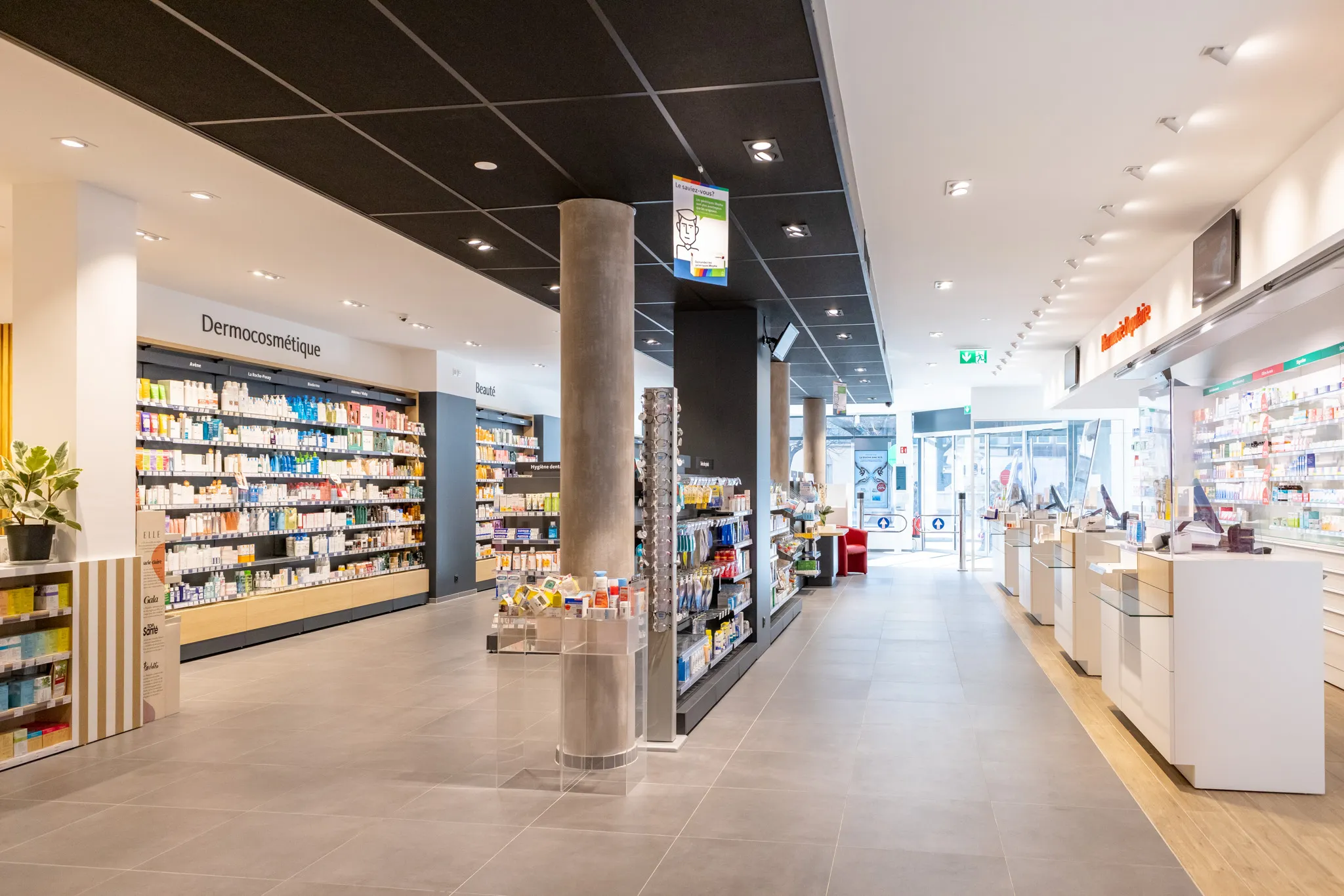 Intérieur lumineux d'une pharmacie avec rayons de produits dermocosmétiques et comptoirs de service