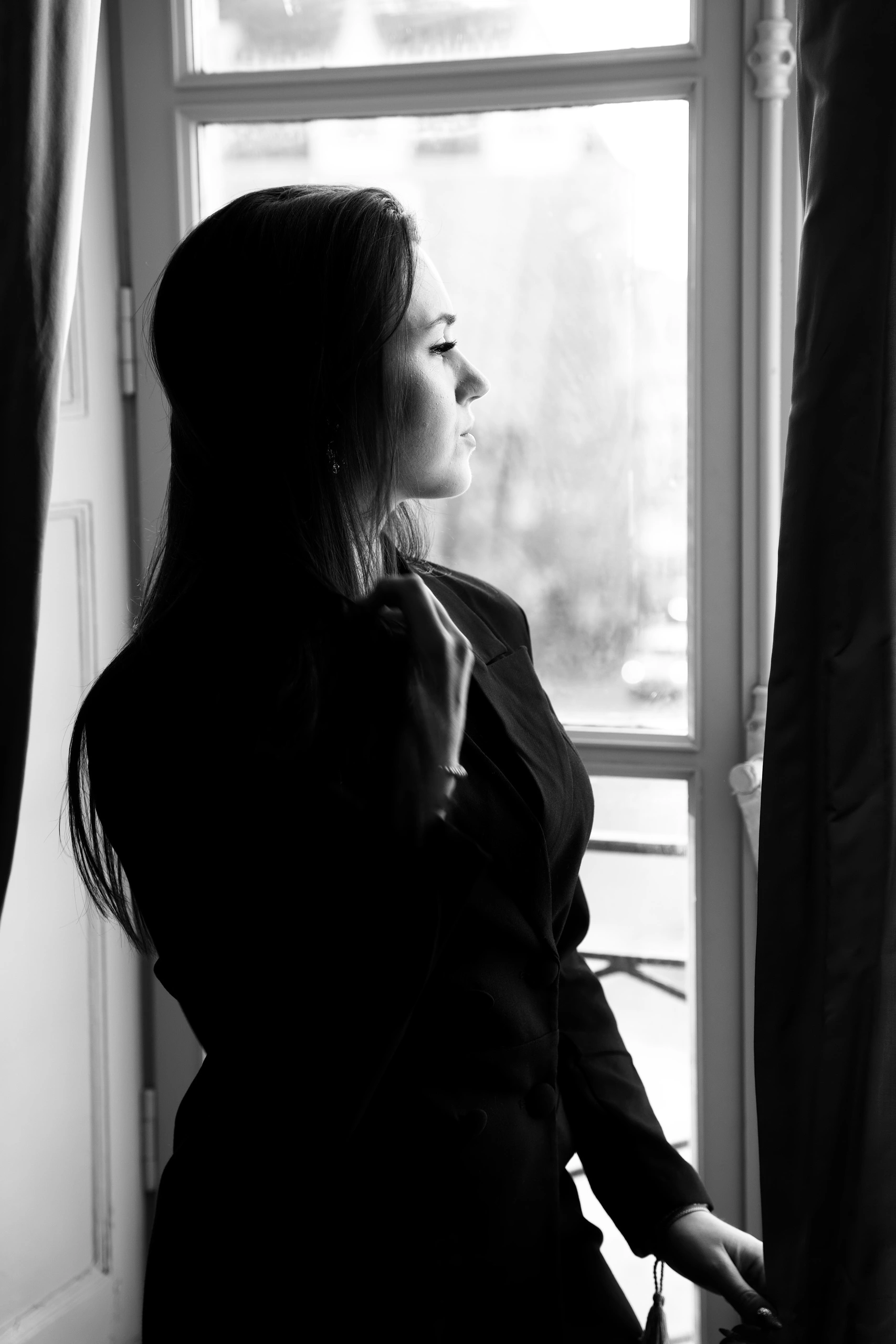 À propos Alexandra en profil regardant par une fenêtre, photo en noir et blanc
